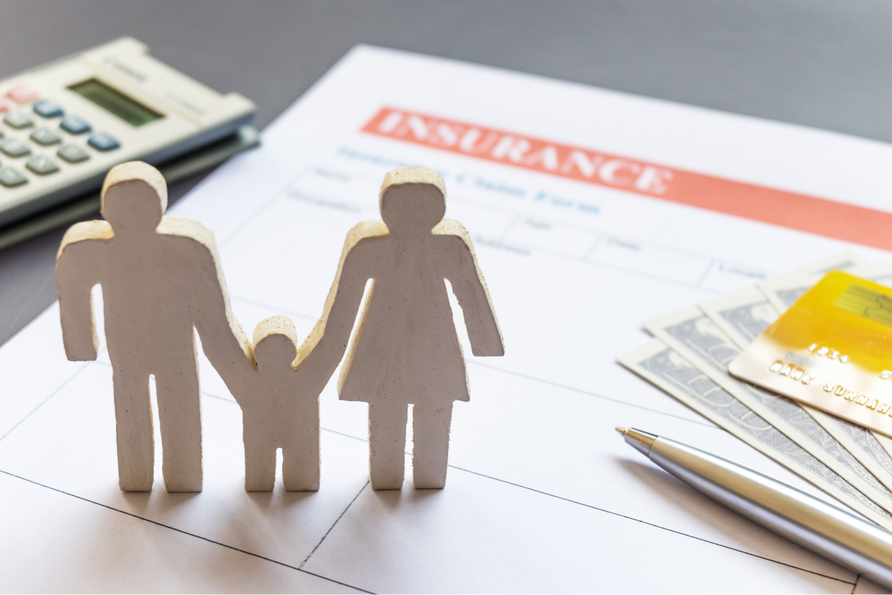 Family figures, credit cards, and documents representing life insurance planning and financial security.