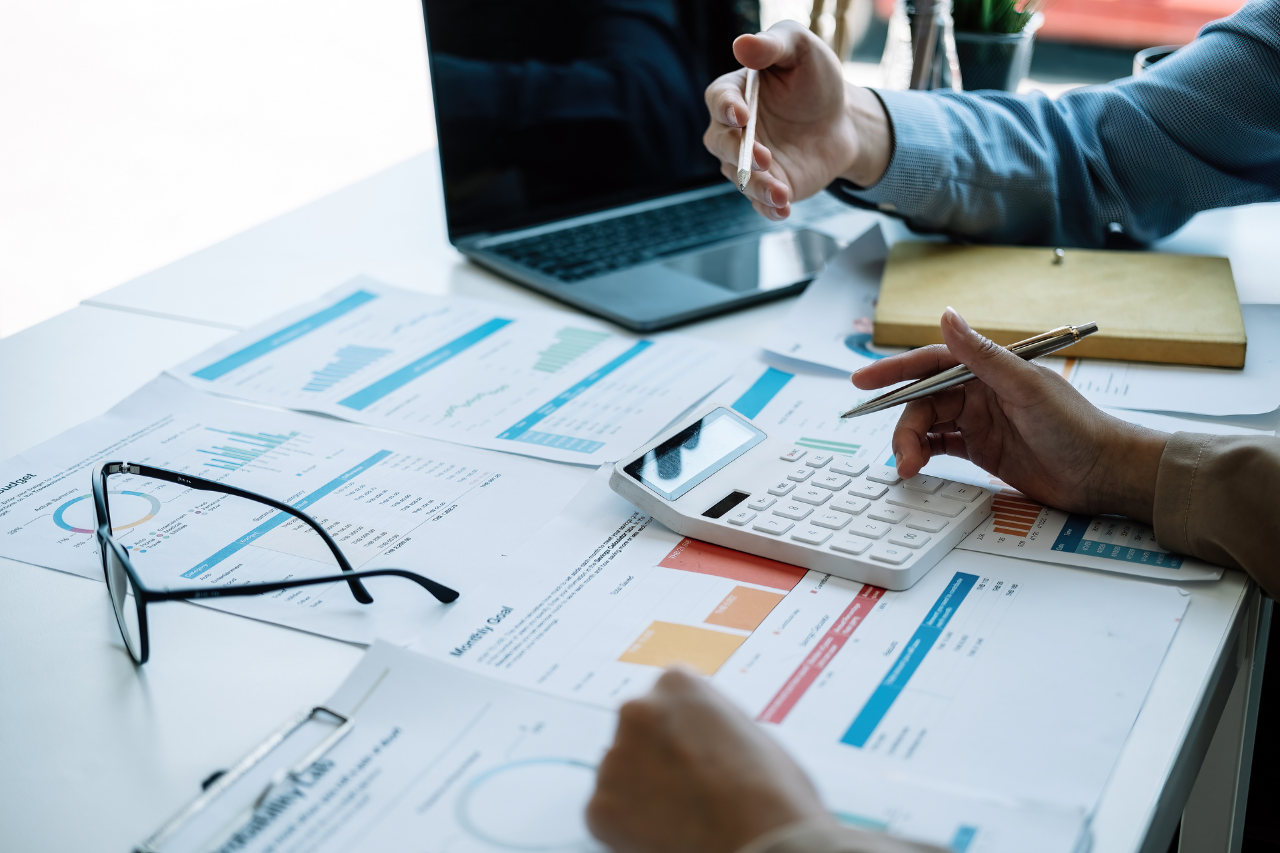 Team discussing charts and using a calculator for retirement planning analysis and strategy